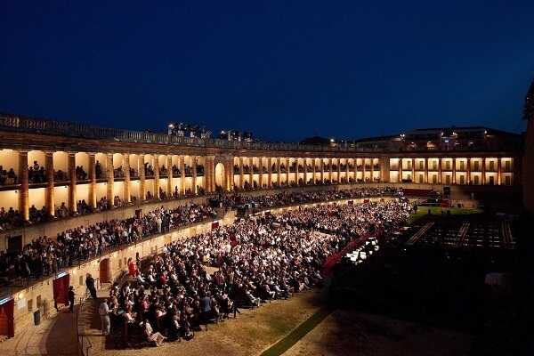 Una bellissima immagine in notturna dello Sferisterio di Macerata con il pubblico pronto ad assistere allo spettacolo