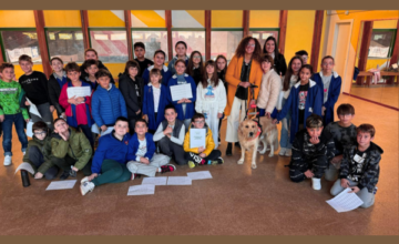 Una bella foto di gruppo: tutti gli studenti posano sorridenti insieme alle insegnanti e alla nostra Alessandra che ha al guinzaglio il bellissimo Basco
